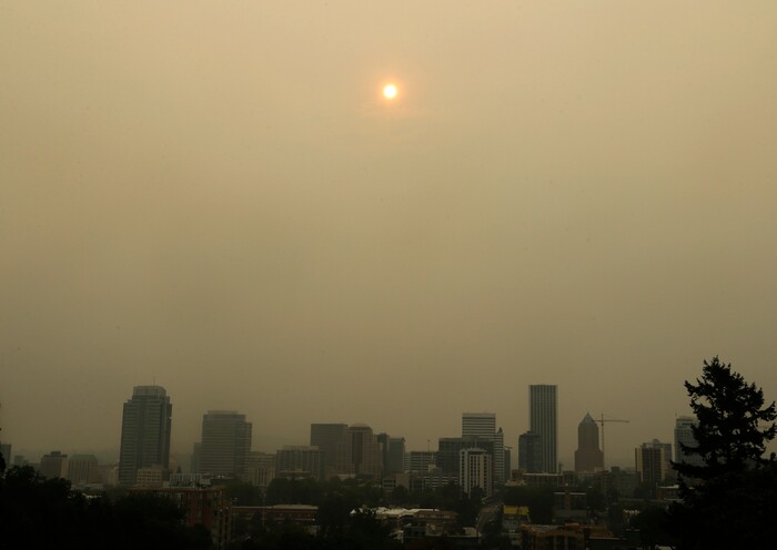 The sun is barely visible over downtown Portland, Ore., Wednesday, Sept. 6, 2017, as seen through smoke from wildfires burning in the Columbia River Gorge east of Portland. The growing blaze east of Portland, Oregon, in the scenic Columbia River Gorge, was one of dozens of wildfires burning in western U.S. states that sent smoke into cities from Seattle to Denver. (AP Photo/Don Ryan)