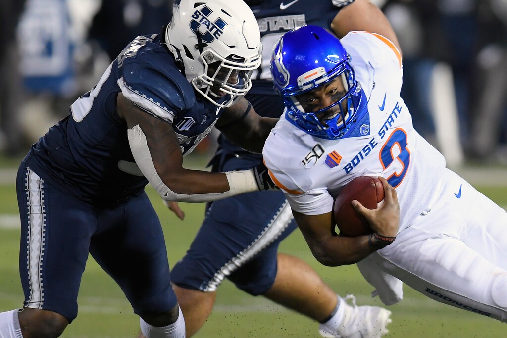 Utah State linebacker Kevin Meitzenheimer tackles Boise State quarterback Jaylon Henderson (9) during the first half of an NCAA college football game Saturday, Nov. 23, 2019, in Logan, Utah. The Aggies will open the abbreviated 2020 season at Boise State on Oct. 24. (AP Photo/Eli Lucero)