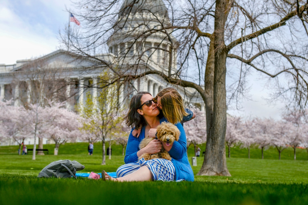 (Leah Hogsten  |  The Salt Lake Tribune) "We try to get out as much as we can," said Stacie Rosenlund, who gets a kiss from her son, Lucas, while taking a break from being indoors due to coronavirus precautions. Thursday's sunshine and fresh air brought many visitors to the Capitol grounds to walk under the blossoming Yoshino cherry trees that line the .7 mile Memorial Walkway encircling Capitol Hill, April 9, 2020.