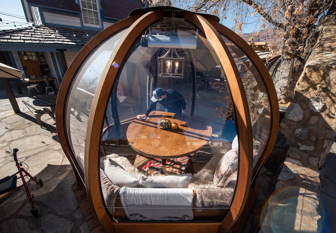 (Francisco Kjolseth  |  The Salt Lake Tribune) Alfredo Acevedo cleans one of three dome-like Alpenglobes set up on the patio at Cafe Galleria in Midway on Thursday, Nov. 5, 2020.