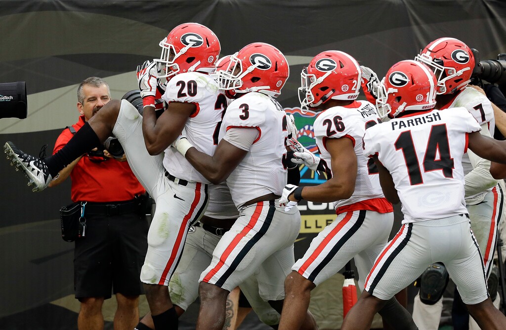 Georgia defensive back J.R. Reed (20) celebrates with teammates including linebacker Roquan Smith (3), defensive back Tyrique McGhee (26) and defensive back Malkom Parrish (14) after he recovered a Florida fumble and scored a touchdown in the second half of an NCAA college football game, Saturday, Oct. 28, 2017, in Jacksonville, Fla. Georgia won 42-7. (AP Photo/John Raoux)