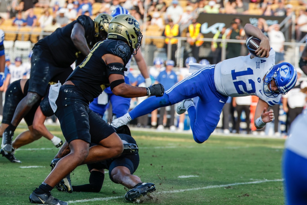 BYU quarterback Jake Retzlaff (12) dives for yardage against the Central Florida defense during the second half of an NCAA college football game, Saturday, Oct. 26, 2024, in Orlando, Fla. (AP Photo/Kevin Kolczynski)