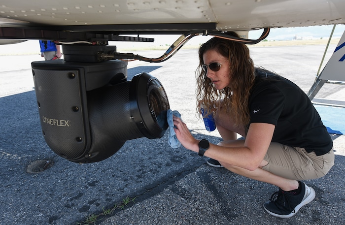 (Francisco Kjolseth  |  Francisco Kjolseth)  Amber Surrency, an aerial research photographer for CoStar Group Inc., cleans the lens on a belly mounted gimbal 5K RED Cineplex camera before a flight over Salt Lake City on Friday, June 8, 2018. The specially equipped Cessna Grand Caravan EX. CoStar Group Inc., a research and technology company provides information to commercial real estate professionals, including those in Utah.