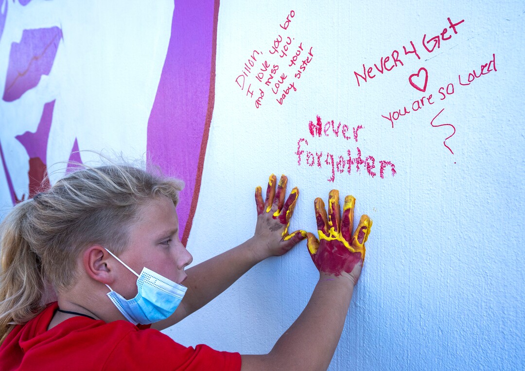 (Rick Egan | The Salt Lake Tribune) Max Thayne 8, puts is hand prints on the wall, near the mural of Dillon Taylor, during a memorial for Dillon, on Wednesday, Aug. 11, 2021.