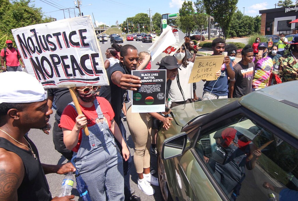 Protestors block University Avenue outside the Wendy's fast food restaurant in Atlanta on Saturday, June 13, 2020, where Rayshard Brooks, a 27-year-old black man, was shot and killed by Atlanta police Friday evening during a struggle in a drive-thru line. (Steve Schaefer/Atlanta Journal-Constitution via AP)