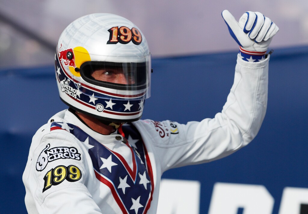 Travis Pastrana celebrates after jumping a row of crushed cars on a motorcycle Sunday, July 8, 2018, in Las Vegas. Pastrana is attempting to recreate three of Evel Knievel's iconic motorcycle jumps on Sunday, including the leap over the fountains of Caesars Palace that left Knievel with multiple fractures and a severe concussion. (AP Photo/John Locher)