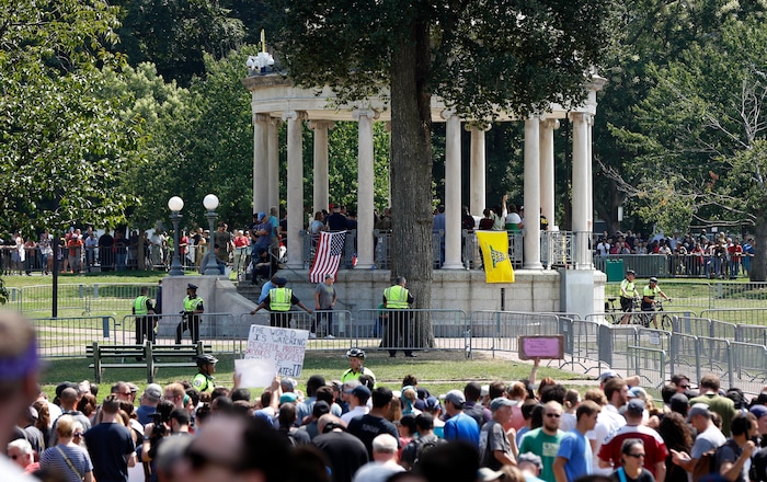 Organizers stand on the bandstand on Boston Common during a "Free Speech" rally staged by conservative activists, Saturday, Aug. 19, 2017, in Boston. Counterprotesters stand along barricades ringing the bandstand. (AP Photo/Michael Dwyer)