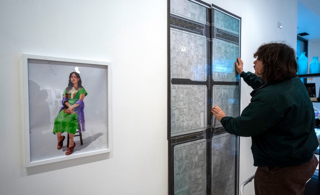 (Rick Egan | The Salt Lake Tribune)  Parviz Faiz hangs a map on the wall at Mestizo Institute of Culture & Arts' gallery at The Gateway, on Friday, Jan. 12, 2024. It's part of a group exhibition, "Love Letters to the West Side."