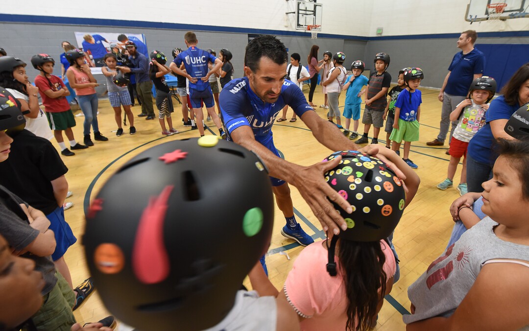 (Francisco Kjolseth  |  The Salt Lake Tribune)  Pro Cyclist Sebastian Haedo helps kids with their new helmets at the Capitol West Boys & Girls Club on Tuesday, July 31, 2018. In advance to the upcoming Tour of Utah bicycle race, more than 50 Salt Lake City-area kids received a new bicycle helmet as part of UnitedHealthcare's Pro Cycling team and community outreach program to keep kids healthy and active. Cyclists Haedo and Jonny Clarke engaged the kids in a few warm up routines before getting on the bike.