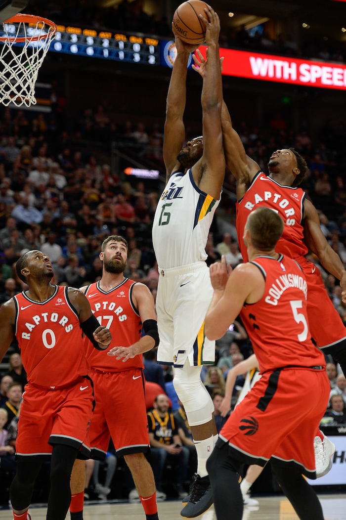 (Francisco Kjolseth  |  The Salt Lake Tribune)  Utah Jazz forward Derrick Favors (15) goes up for a shot past the Raptors in the first half of the preseason NBA game at Vivint Smart Home Arena Tuesday, Oct. 2, 2018, in Salt Lake City.