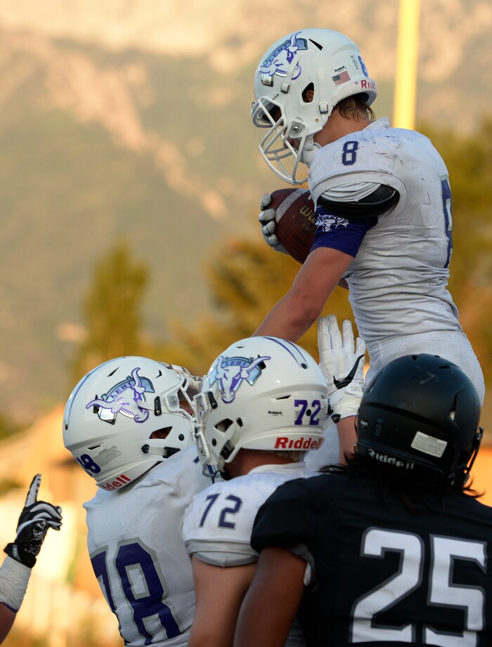 (Leah Hogsten  |  The Salt Lake Tribune) Lehi's Carsen Manookin celebrates his first half touchdown with the team.  Lehi High School leads Alta High School 42-35 during their game, Friday, August 18, 2017 in Sandy. 