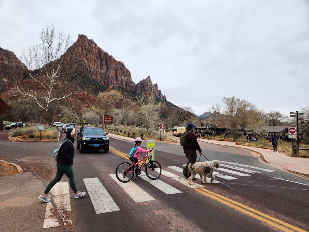 (National Park Service) Parkgoers cross a busy street near the south entrance at Zion National Park.