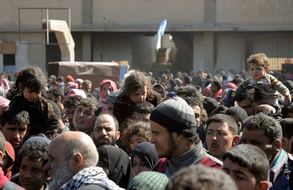 (SANA via The Associated Press) This photo released by the Syrian official news agency SANA, shows Syrian civilians with their belongings as they flee from fighting between the Syrian government forces and rebels, near Hamouria in eastern Ghouta, a suburb of Damascus, Syria, Friday, March. 16, 2018. The government offensive has pushed further into eastern Ghouta, chipping away at one of the largest and most significant opposition bastions since the early days of the rebellion, communities where some 400,000 people are estimated to be holed up.