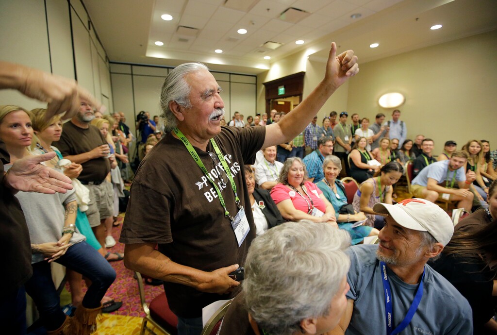 FILE - In this Aug. 4, 2016, file photo, shows Willie Grayeyes, of the Utah Dine Bikeyah raising his hand as he is recognized during a news conference, in Salt Lake City. Navajo Nation leaders are protesting a Utah county's investigation into a Navajo candidate's residency, saying it's an attempt to disqualify a native contender after a federal judge decided voting districts discriminated against Navajos. San Juan County spokeswoman Natalie Callahan countered Friday, April 27, 2018, that the investigation into a citizen complaint questioning whether Democratic candidate Willie Grayeyes lives on the Utah side of the nearby Arizona border isn't related to politics or race. (AP Photo/Rick Bowmer, File)
