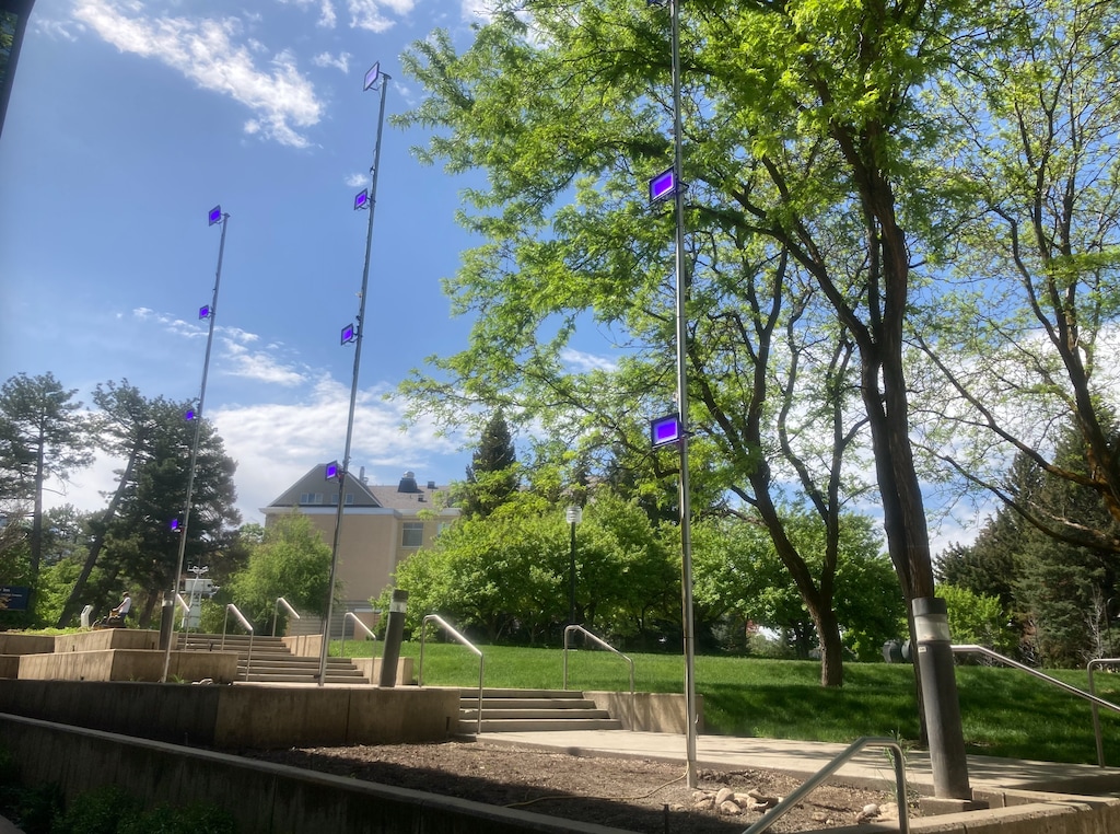 (Mark Koven) Poles outside Utah State University’s on-campus inn were outfitted with ultraviolet lights aimed at its “bird death zone” windows.  The experiment by professors Kimberly Sullivan and Mark Koven reduced the number of birds who were killed by striking the glass.