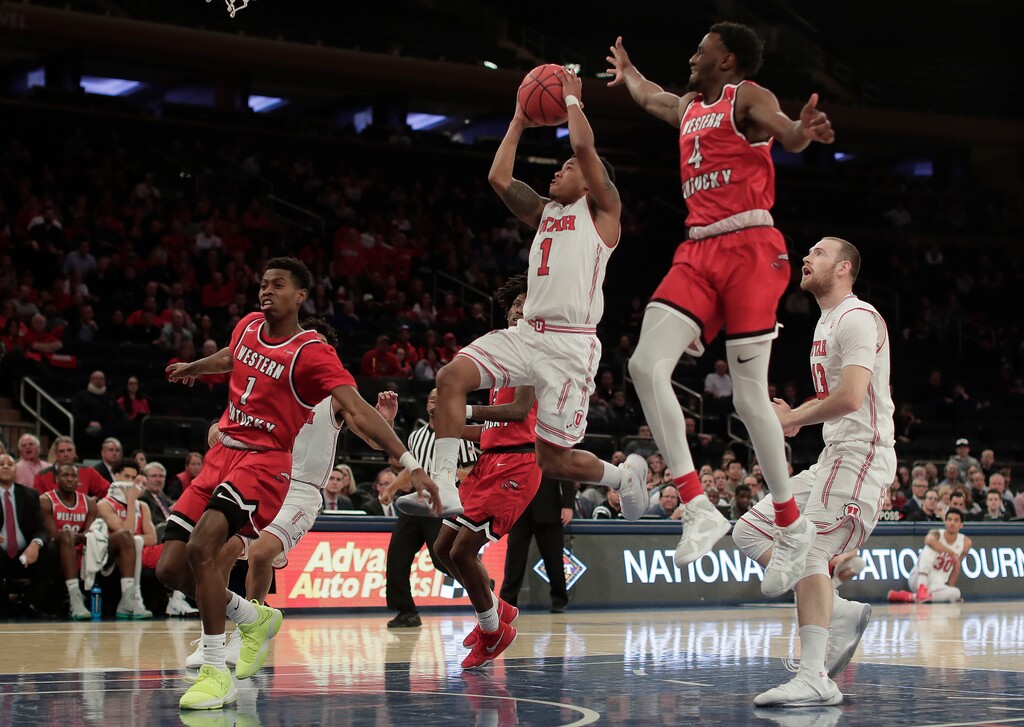 Utah guard Justin Bibbins (1) drives to the basket as Western Kentucky guards Lamonte Bearden (1) and Josh Anderson (4) defend during the first half of an NCAA college basketball game in the semifinals of the NIT, Tuesday, March 27, 2018, in New York. (AP Photo/Julie Jacobson)