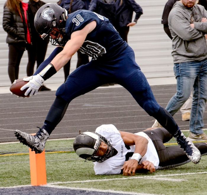(Steve Griffin  |  The Salt Lake Tribune)  Corner Canyon's Caden Johnson gets past Highland's Trayton Keyes as he stretches the ball across the goal line during the Class 5A state quarterfinal football game at Corner Canyon in Draper Friday November 3, 2017.