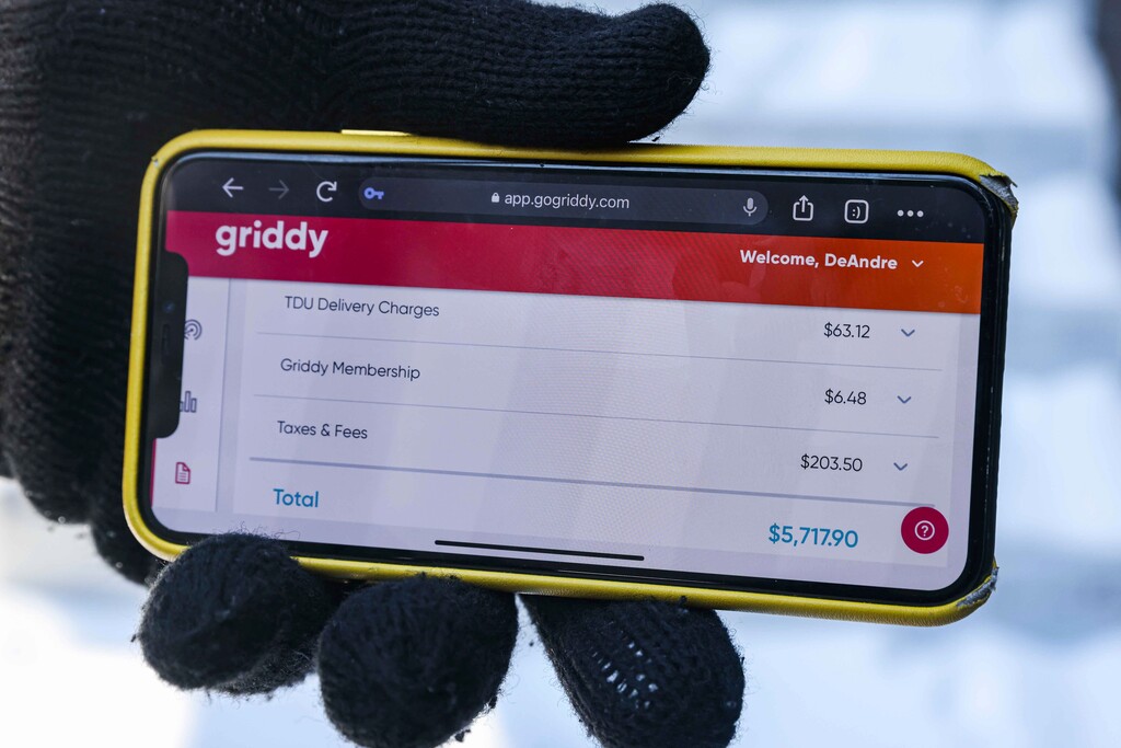 (Lola Gomez | The Dallas Morning News via AP)
DeAndré Upshaw shows a $5,000 bill from Griddy on his cell phone for his 900-square-foot apartment during very cold weather in Dallas, on Friday, Feb. 19, 2021. The Texas power supplier Griddy, which sells unusual plans with prices tied to the spot price of power on the Texas grid, warned its customers over the weekend that their bills would rise significantly during the storm and that they should switch providers.