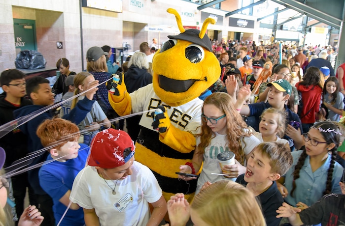 (Francisco Kjolseth  |  The Salt Lake Tribune)  Bumble unloads the silly string on young fans while being mobbed by the kids during the annual staging of the kids day game on Thursday, May 2, 2019 at Smith's Ballpark in Salt Lake.