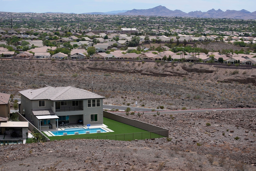 (John Locher | AP) A home with a swimming pool abuts the desert on the edge of the Las Vegas valley July 20, 2022, in Henderson, Nev. Nevada lawmakers on Monday, March 13, 2023, will consider another shift in water use for one of the driest major metropolitan areas in the U.S. The water agency that manages the Colorado River supply for Vegas is seeking authority to limit what comes out of residents' taps.