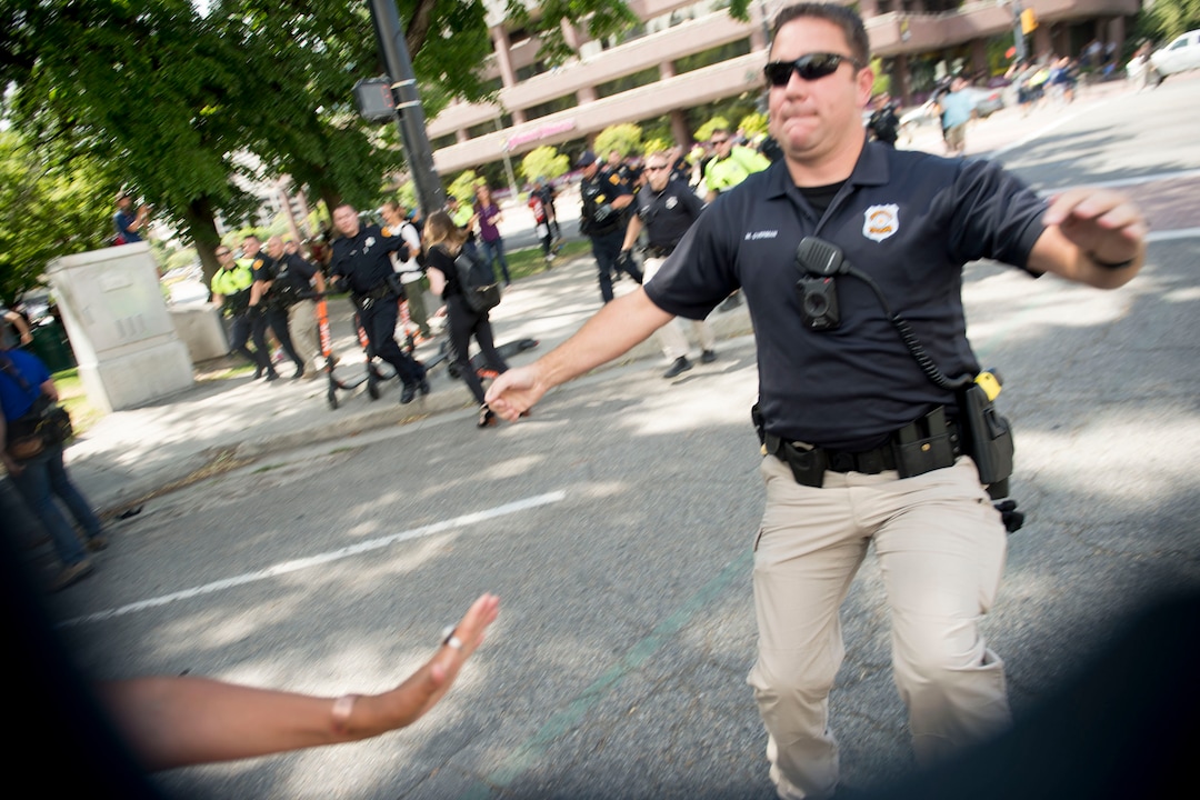 (Jeremy Harmon |  The Salt Lake Tribune) Police run in after protesters attacked one news photographer and chased another one following an inland port protest on Tuesday, July 9, 2019.