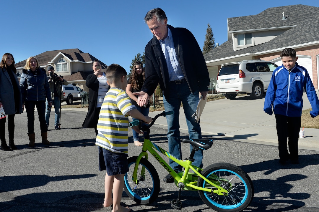 (Scott Sommerdorf | The Salt Lake Tribune) Mitt Romney stops to shake hands with six year old Cooper Aznar as he collects signatures in Orem, Saturday, Feb. 17, 2018, after announcing his campaign for U.S. Senate to replace Orrin Hatch.