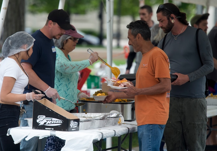 (Rick Egan  |  The Salt Lake Tribune)      
Volunteers serve food to the homeless as the Salt Lake City Mission fed and donated clothes to the homeless in Pioneer Park on Memorial day, Monday, May 28, 2018.


