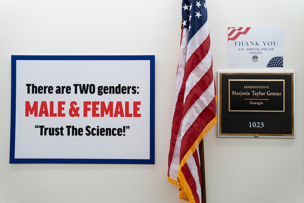 (Stefani Reynolds | The New York Times)
Rep. Marjorie Taylor Greene (R-Ga.) placed a sign outside her office stating there are two genders, male and female, after Rep. Marie Newman (D-Ill.), whose office is across the hall, placed a transgender pride flag, outside her office in Longworth House Office Building in Washington after the passage of the Equality Act on Feb. 25, 2021.