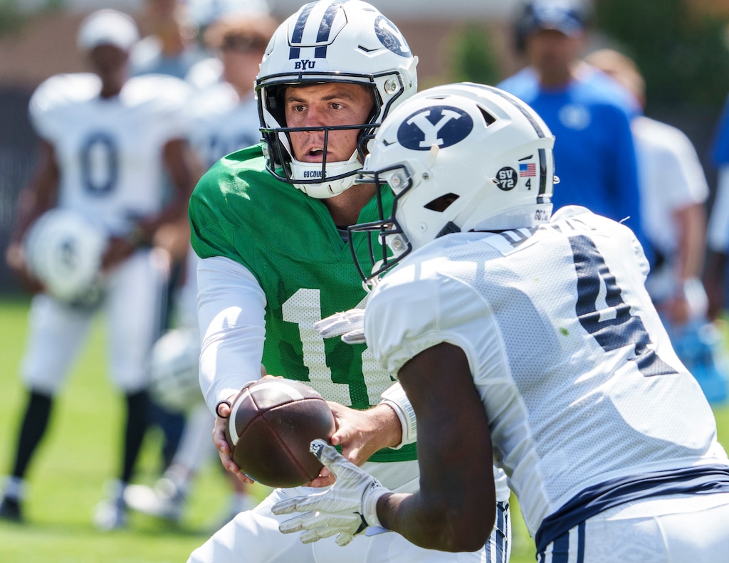 (Leah Hogsten | The Salt Lake Tribune) Brigham Young University quarterback Jake Retzlaff hands off to running back Miles Davis during football practice Aug. 8, 2023 in Provo. 