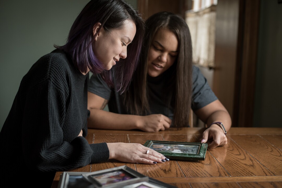 (Caroline Yang | The Washington Post) Alec's sisters Brittany Smith, left, and Alexis Holt look at old family photos.
