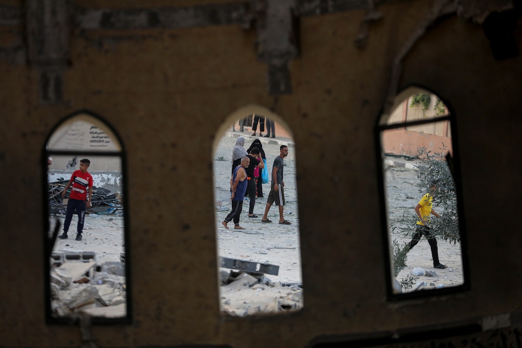(Yousef Masoud | AP) People stand outside a mosque destroyed in an Israeli air strike in Khan Younis, Gaza Strip, Sunday, Oct. 8, 2023. The Hamas militants broke out of the blockaded Gaza Strip and rampaged through nearby Israeli communities, taking captives, while Israel's retaliation strikes leveled buildings in Gaza.