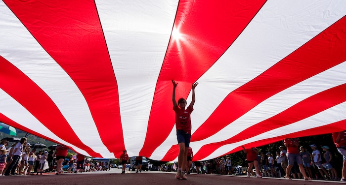 (Rick Egan | The Salt Lake Tribune) Marchers carry a giant American Flag, in the Cherry Days Fourth of July Parade, in North Ogden, on Monday, July 4, 2022.