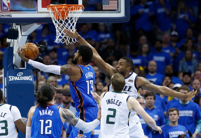 Oklahoma City Thunder forward Paul George (13) shoots in front of Utah Jazz forward Derrick Favors, back right, during the second half of Game 5 of an NBA basketball first-round playoff series in Oklahoma City, Wednesday, April 25, 2018. (AP Photo/Sue Ogrocki)