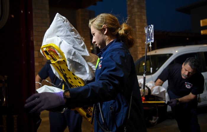 In this Jan. 19, 2018, photo, Lehi firefighter and paramedic Aubrey Freiberg helps fellow firefighters load a patient into an ambulance after they responded to a medical call at Pointe Meadows Health and Rehabilitation in Lehi, Utah. (Isaac Hale/The Daily Herald via AP)