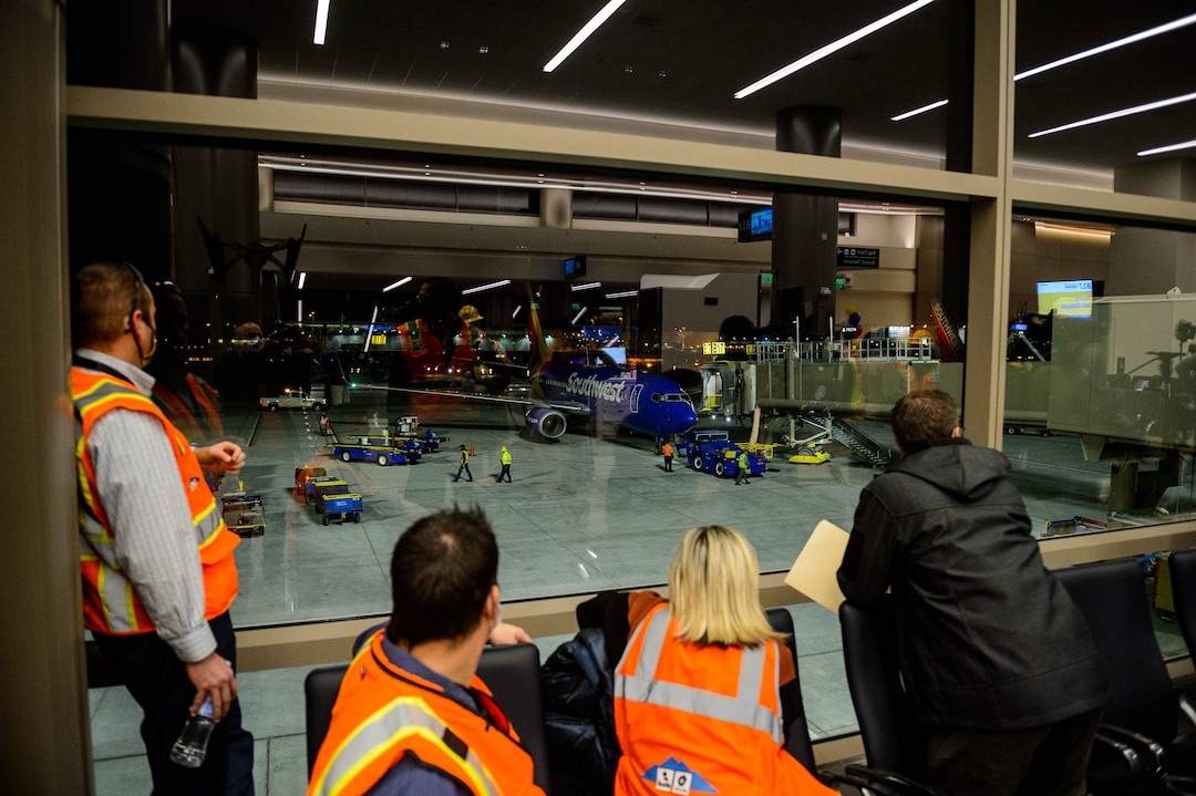 (Trent Nelson  |  The Salt Lake Tribune) Workers reflected in the window look on as the first flight from concourse B at the Salt Lake City International Airport, a Southwest flight to Oakland, prepares to take off on Tuesday, Oct. 27, 2020.