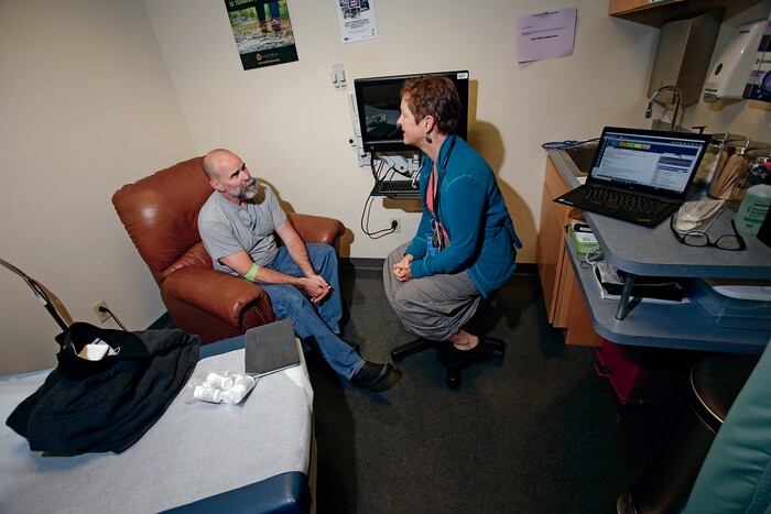(Luis Sánchez Saturno | Santa Fe New Mexican | The Associated Press) In this Wednesday, April 25, 2018 photo, Dr. Laura Dwyer, right, meets with Patrick Coss, of Santa Fe, at Southwest Care in Santa Fe, N.M. The HIV/AIDS clinic has been at the forefront of AIDS research over the past 30 years.