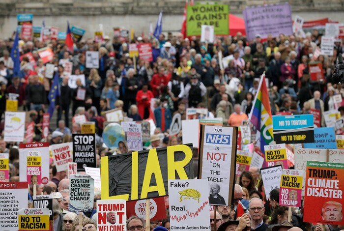 People carry signs and banners as they gather in Trafalgar Square, central London, to demonstrate against the state visit of President Donald Trump, Tuesday, June 4, 2019. Trump will turn from pageantry to policy Tuesday as he joins British Prime Minister Theresa May for a day of talks likely to highlight fresh uncertainty in the allies' storied relationship. (AP Photo/Tim Ireland)