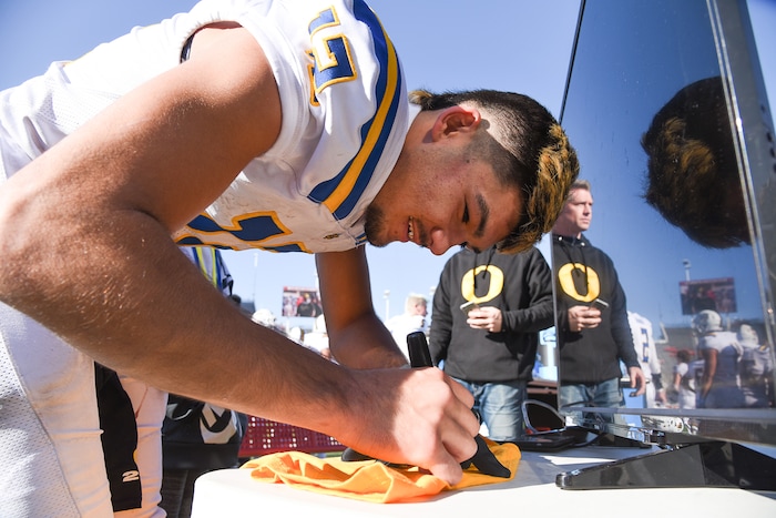 (Francisco Kjolseth  |  The Salt Lake Tribune)  Orem's Puka Nacua signs a shirt for a young fan after clutching the state record for touchdowns with 26 against Dixie in the 4A high school championship game at Rice Eccles Stadium in Salt Lake City, Friday, Nov. 16, 2018.
