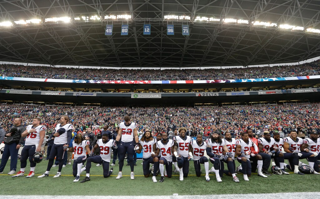 FILE - In this Oct. 29, 2017, file photo, Houston Texans players kneel and stand during the singing of the national anthem before an NFL football game against the Seattle Seahawks, in Seattle. NFL owners have approved a new policy aimed at addressing the firestorm over national anthem protests, permitting players to stay in the locker room during the "The Star-Spangled Banner" but requiring them to stand if they come to the field. The decision was announced Wednesday, May 23, 2018, by NFL Commissioner Roger Goodell during the league's spring meeting in Atlanta. (AP Photo/Elaine Thompson, File)