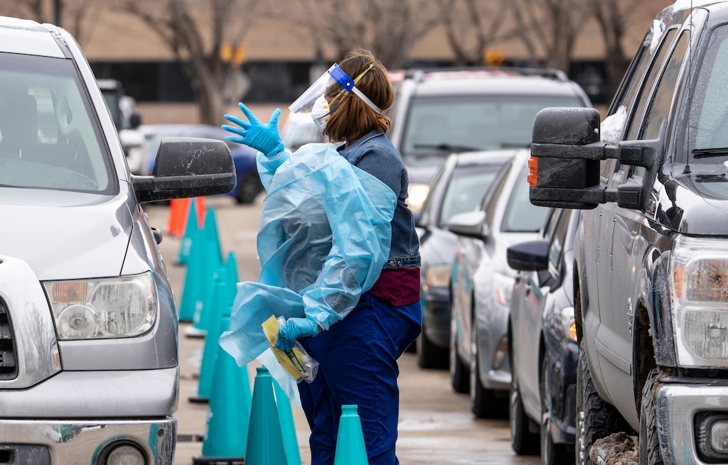 (Leah Hogsten | The Salt Lake Tribune) A steady line of vehicles filled with multiple people waiting to be tested for Covid19 are tended to by members of the Utah Department of Health at the Cannon Health Building, Dec. 27, 2021. 