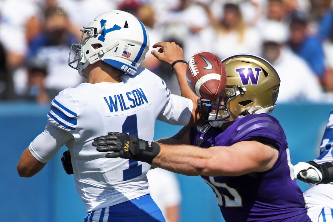 BYU quarterback Zach Wilson (1) fumbles the ball as he is hit by Washington linebacker Ryan Bowman (55) in the first half during an NCAA college football game, Saturday, Sept. 21, 2019, in Provo, Utah. (AP Photo/George Frey)