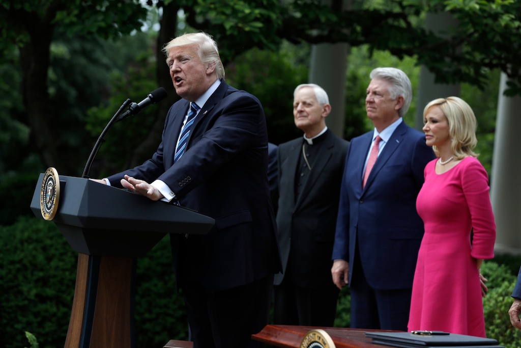 (Evan Vucci | AP file photo )Paula White stands behind President Donald Trump as he speaks the White House on May 4, 2017 before signing an executive order aimed at easing an IRS rule limiting political activity for churches.Also pictured are From second from left are, Cardinal Donald Wuerl is the Archbishop of Washington,and Pastor Jack Graham.
