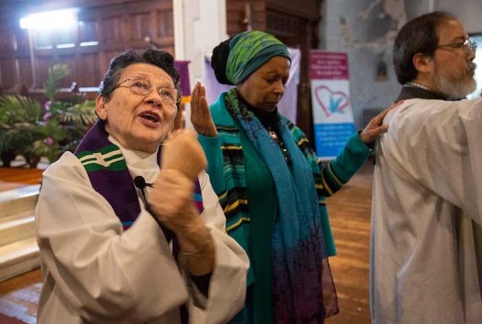 In this Sunday, Dec. 15, 2019, photo, the Rev. Maria Santiviago, left, signs the sermon for deaf worshippers at Holyrood Episcopal Church-Iglesia Santa Cruz in New York. Santiviago is a 77-year-old Paraguayan who came out of retirement to help lead the ministry for the deaf. (AP Photo/Jessie Wardarski)