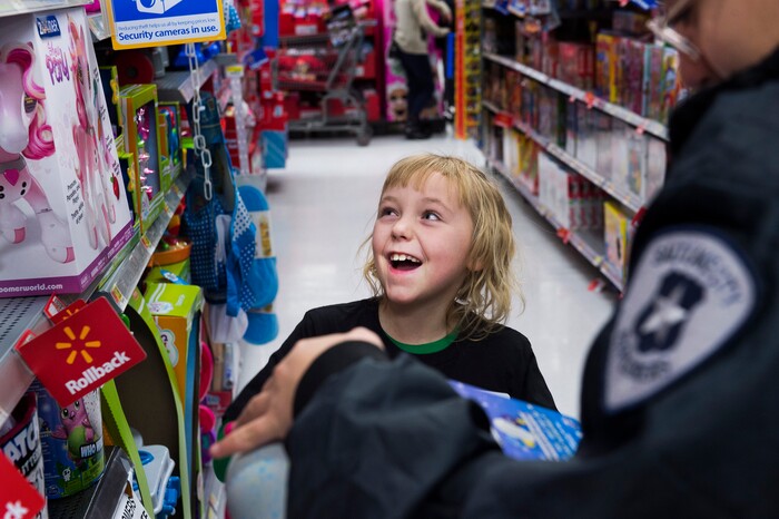 (Scott Sommerdorf   |  The Salt Lake Tribune)   
Macadia Meyer lights up as she spots the toy she wanted to get for her sister while shopping with Officer Jose Munoz in the Walmart toy aisle at the first ever Police Pay It Forward event, Saturday, December 16, 2017.