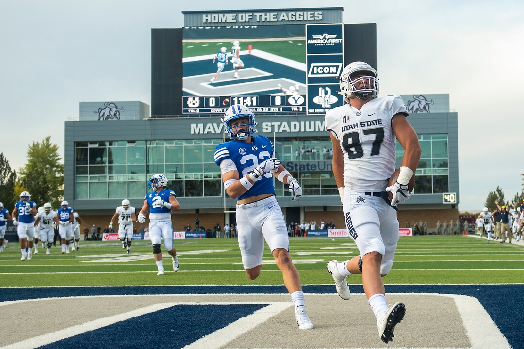 (Chris Detrick  |  The Salt Lake Tribune)  Utah State Aggies tight end Dax Raymond (87) scores a touchdown past Brigham Young Cougars defensive back Zayne Anderson (23) during the game at Merlin Olsen Field at Maverik Stadium Friday, September 29, 2017.