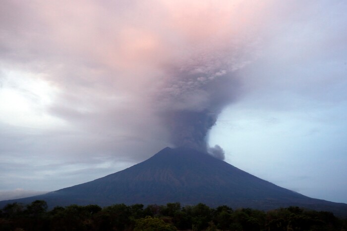 (Firdia Lisnawati | The Associated Press) Clouds of ashes rise from the Mount Agung volcano erupting in Karangasem, Indonesia, Monday, Nov. 27, 2017. Indonesia authorities raised the alert for the rumbling volcano to highest level on Monday and closed the international airport on tourist island of Bali stranding thousands of travelers.