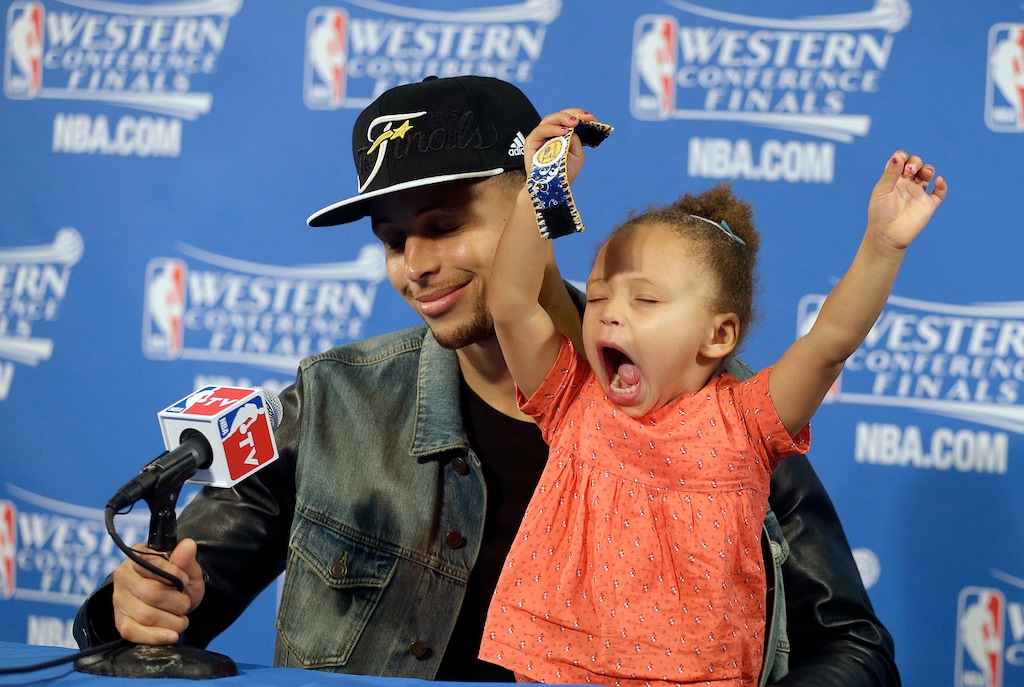 FILE - In this May 27, 2015, file photo, Golden State Warriors guard Stephen Curry is joined by his daughter Riley at a news conference after Game 5 of the NBA basketball Western Conference finals against the Houston Rockets in Oakland, Calif. Curry has been named The Associated Press 2015 Male Athlete of the Year. (AP Photo/Ben Margot, File)