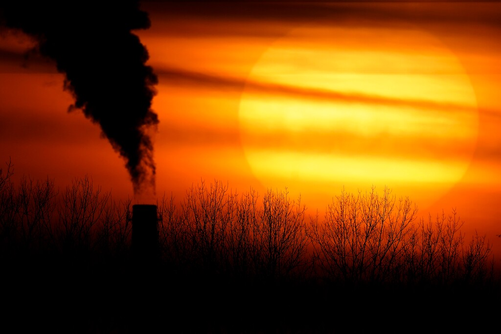 FILE - In this Monday, Feb. 1, 2021 file photo, emissions from a coal-fired power plant are silhouetted against the setting sun in Independence, Mo.  (AP Photo/Charlie Riedel)