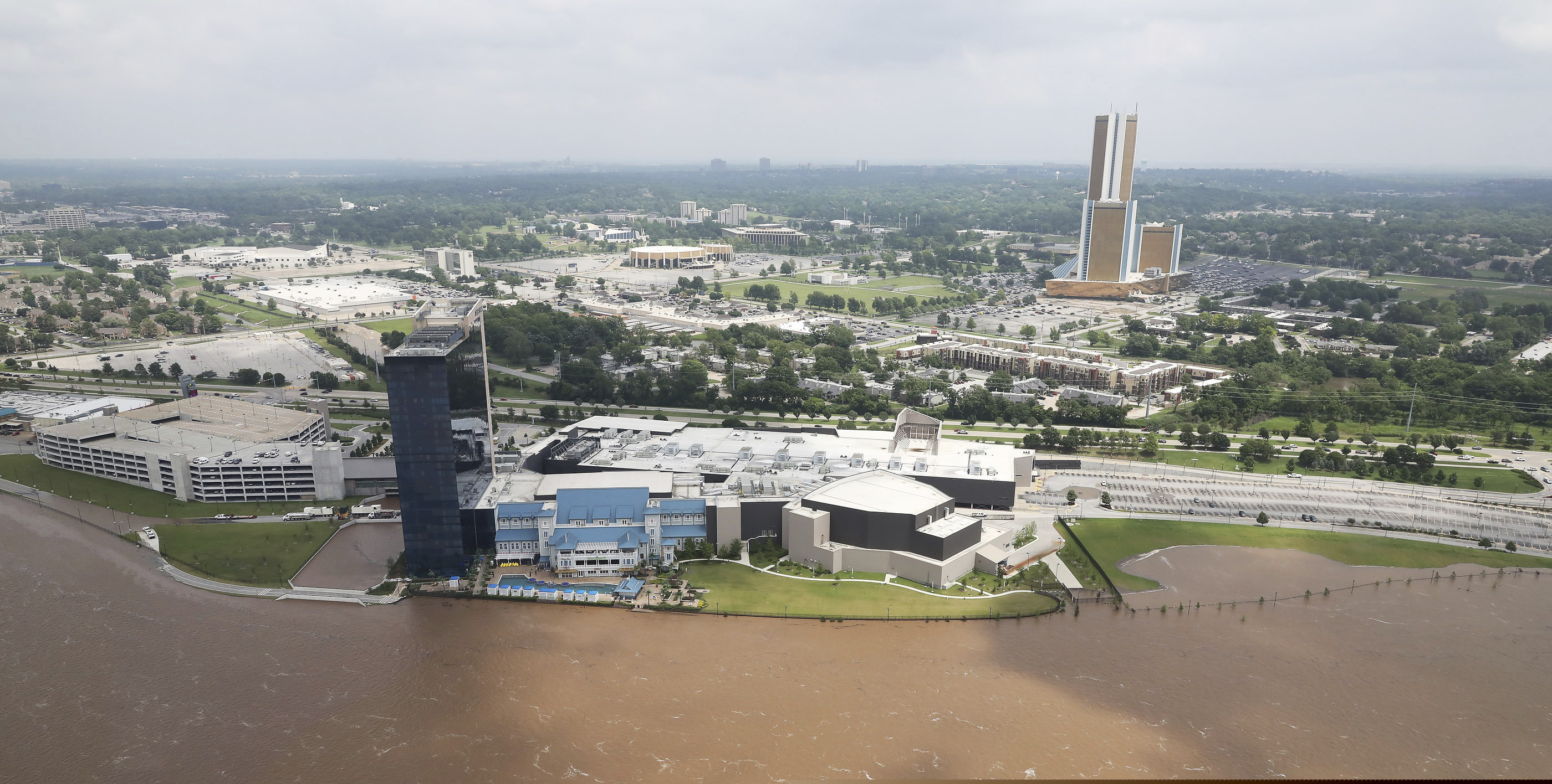 (Tom Gilbert/Tulsa World via AP) Flood waters encroach the River Spirit Hotel and Casino in Tulsa, Okla., on Wednesday, May 22, 2019. Authorities on Wednesday encouraged people living along the Arkansas River in the Tulsa suburb of Bixby and low-lying areas near creeks both north and south of Okmulgee, about 35 miles (56 kilometers) south of Tulsa. to leave their homes.