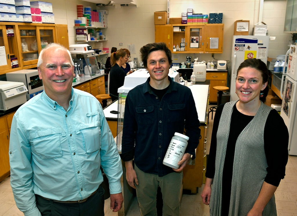 In this photo taken Nov. 29, 2018, from left, Kevin McKelvey, Thomas Franklin and Jessie Golding stand in the National Genomics Center for Wildlife and Fish Conservation in Missoula, Mont. A paw print in the snow contains enough genetic clues to identify the animal that made it, even if the track has been buried for five months. That discovery may revolutionize and simplify wildlife monitoring in remote places. (Tom Bauer/The Missoulian via AP)